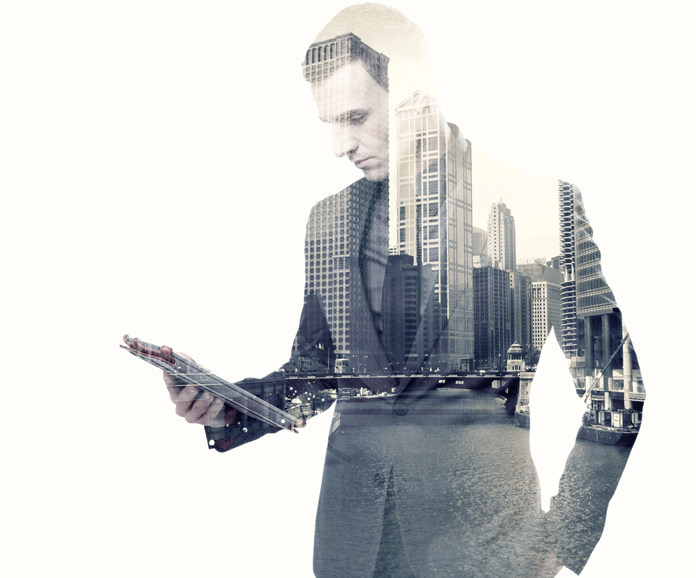 Double exposure of a businessman and a city using a tablet over white background