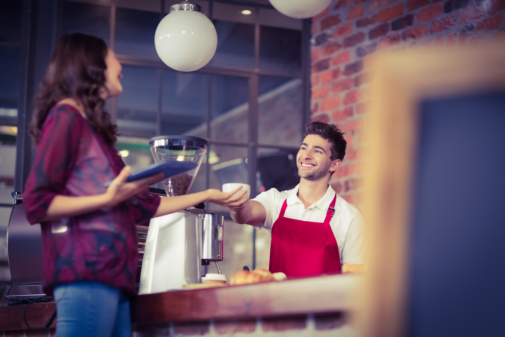 Smiling waiter serving a client at the coffee shop-1